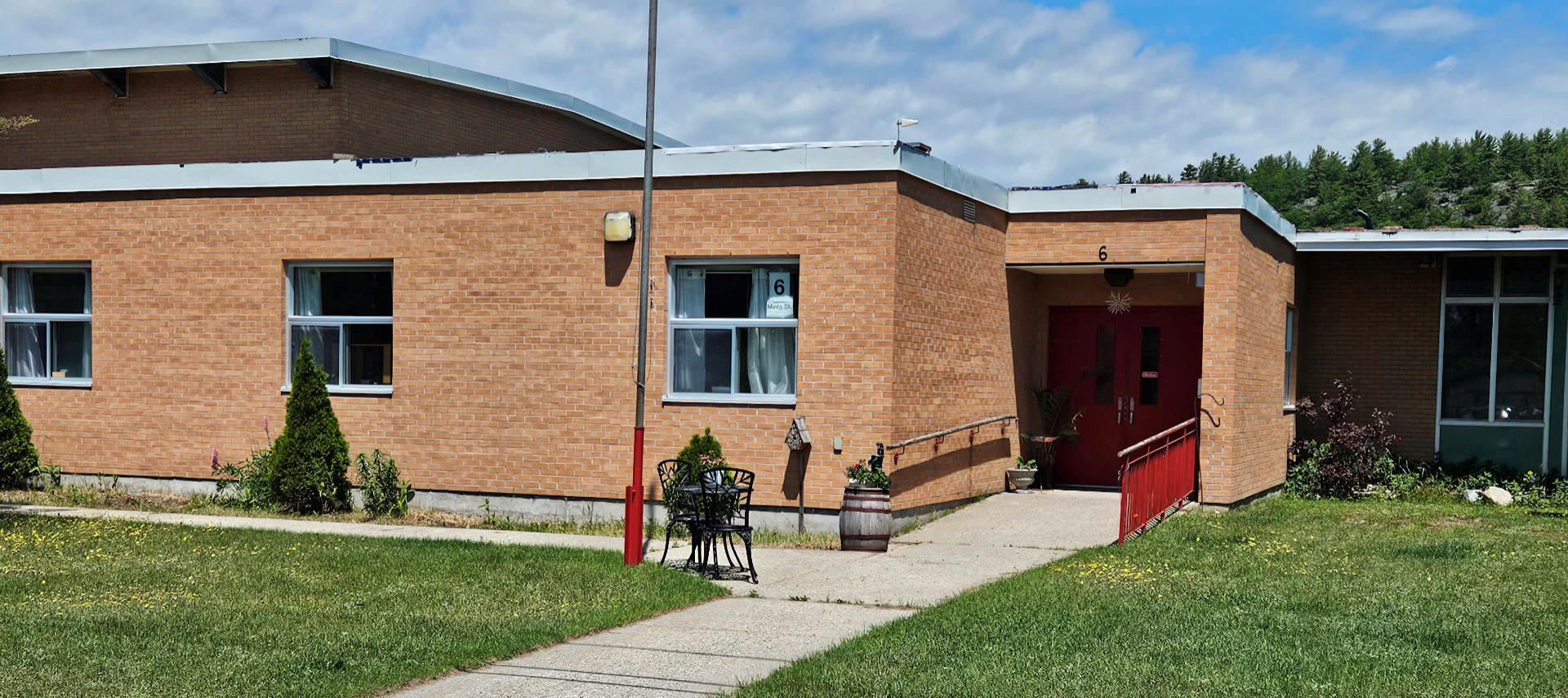 Outside picture of the Webbwood Public School looking on the library and front door on a sunny summer day